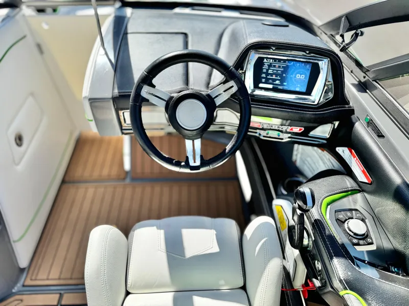 Slide: The Image of 2016 Nautique Super Air G23 boat cockpit with steering wheel and digital display. - 37