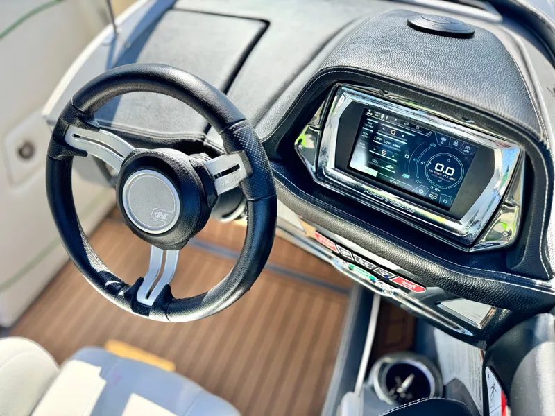 Slide: The Image of 2016 Nautique Super Air G23 dashboard with steering wheel and digital display. - 38