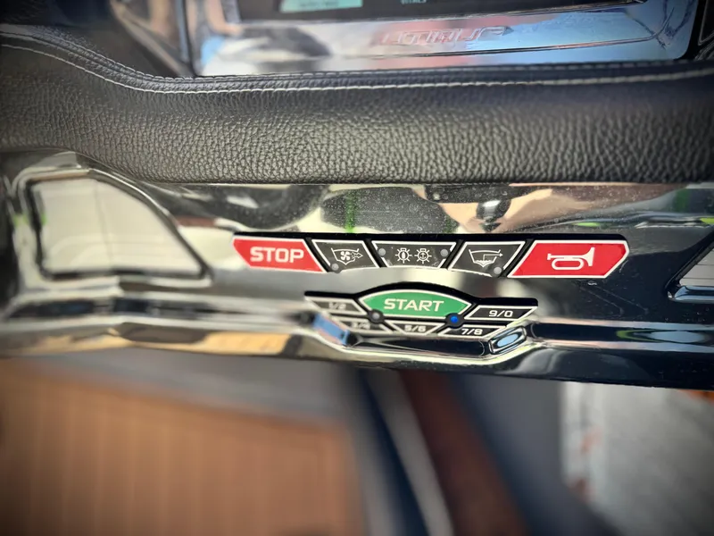 Slide: The Image of Control panel of a 2016 Nautique Super Air G23 boat with start and stop buttons. - 40