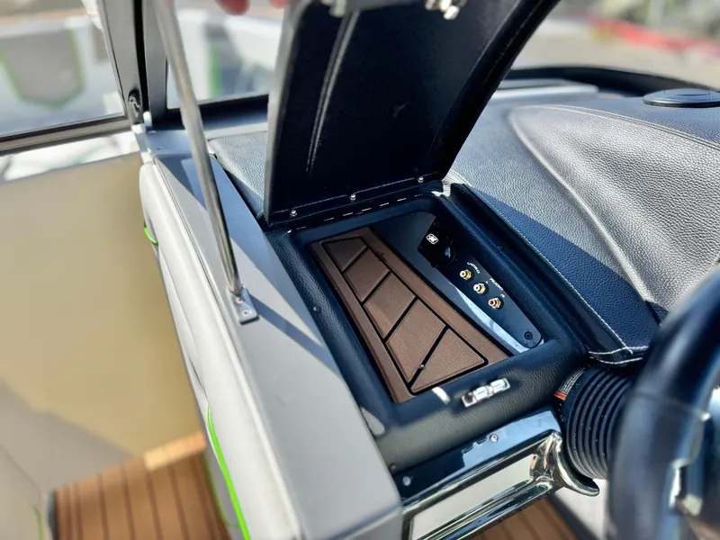 Slide: The Image of 2016 Nautique Super Air G23 dashboard compartment with open lid and control panel. - 41