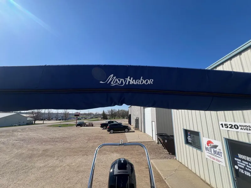 Slide: The Image of 2019 Misty Harbor 2285 Biscayne Bay CU boat with blue canopy in a parking lot. - 22