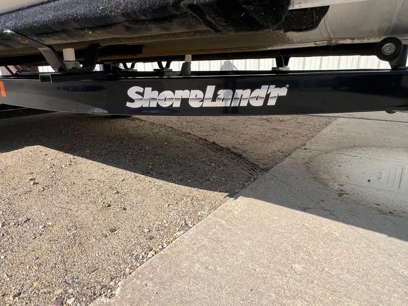 Slide: The Image of ShoreLand'r trailer under Misty Harbor 2285 Biscayne Bay CU, 2019 model, on concrete surface. - 26