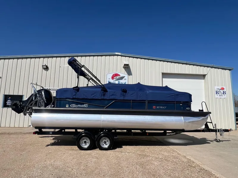 Slide: The Image of 2019 Misty Harbor 2285 Biscayne Bay CU pontoon boat on trailer, covered, outside building. - 28