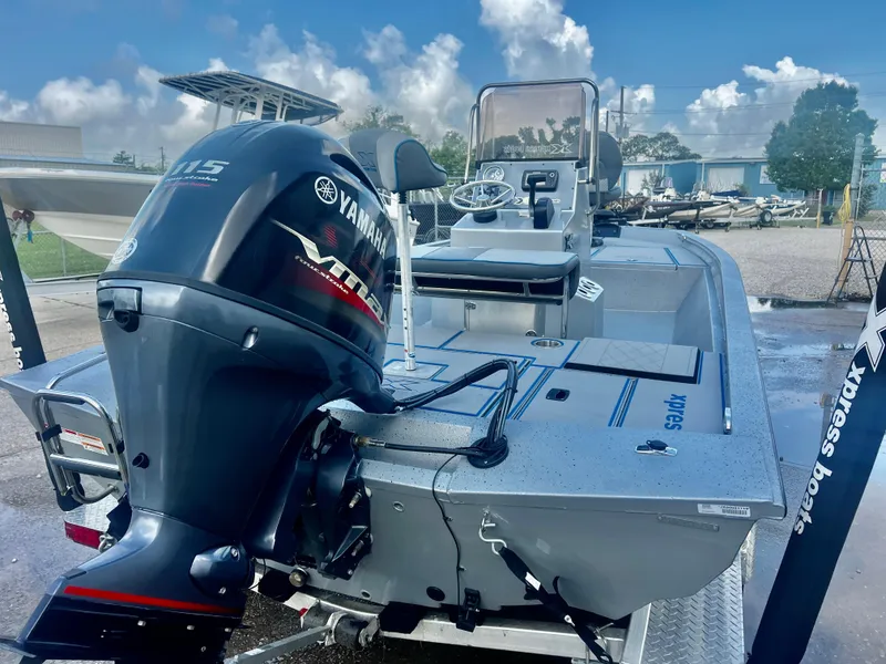 Slide: The Image of 2023 Xpress H190B boat with Yamaha outboard motor, parked outdoors under a blue sky. - 2