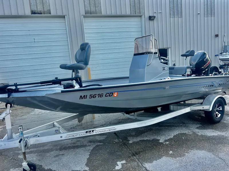 Slide: The Image of 2023 Xpress H190B boat on trailer, parked outside industrial building. - 4