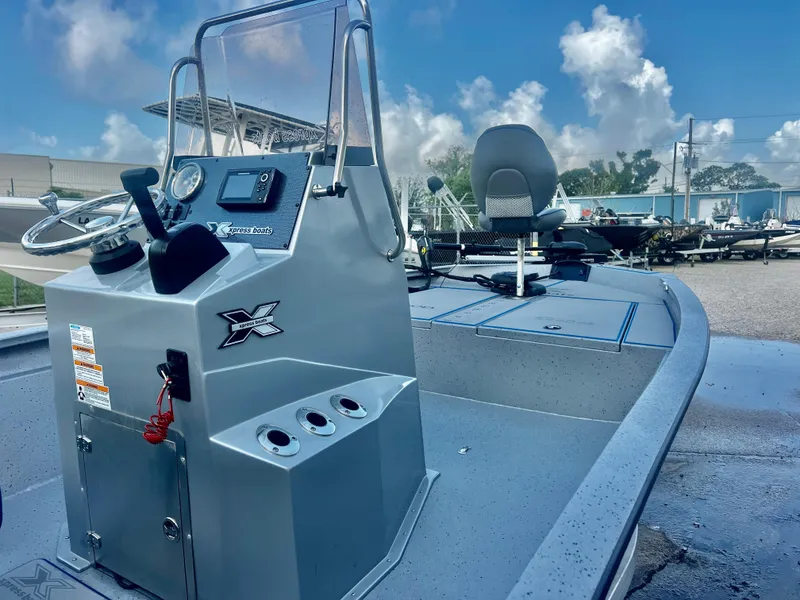 Slide: The Image of 2023 Xpress H190B boat with console and seating, under a clear blue sky. - 6