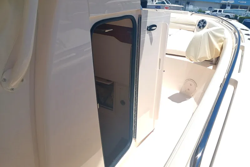 Slide: The Image of 2025 Grady-White Canyon 326 boat interior with open cabin door and seating area. - 20
