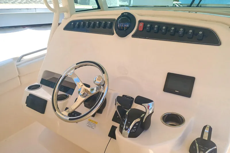 Slide: The Image of 2025 Grady-White Canyon 326 helm with steering wheel and control panel. - 21