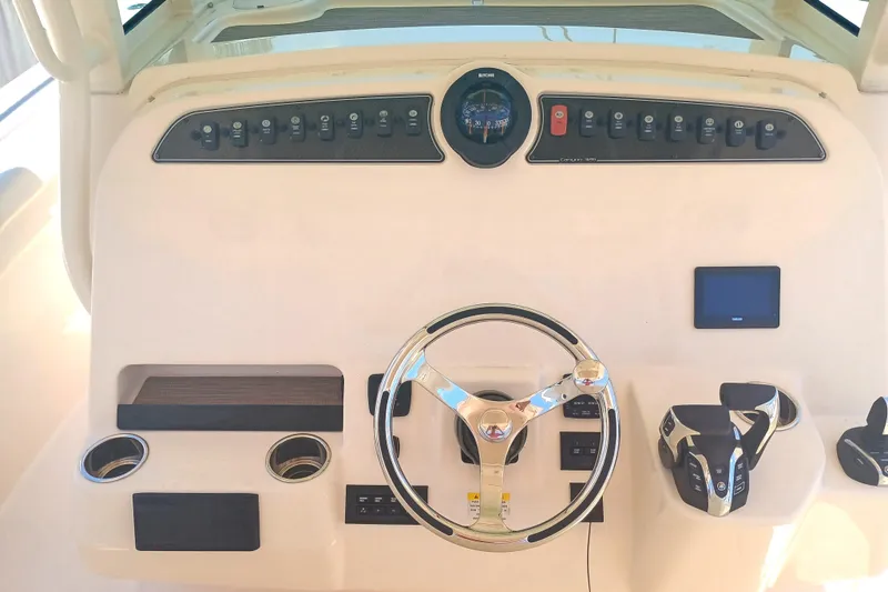 Slide: The Image of 2025 Grady-White Canyon 326 helm with steering wheel, controls, and dashboard instruments. - 22