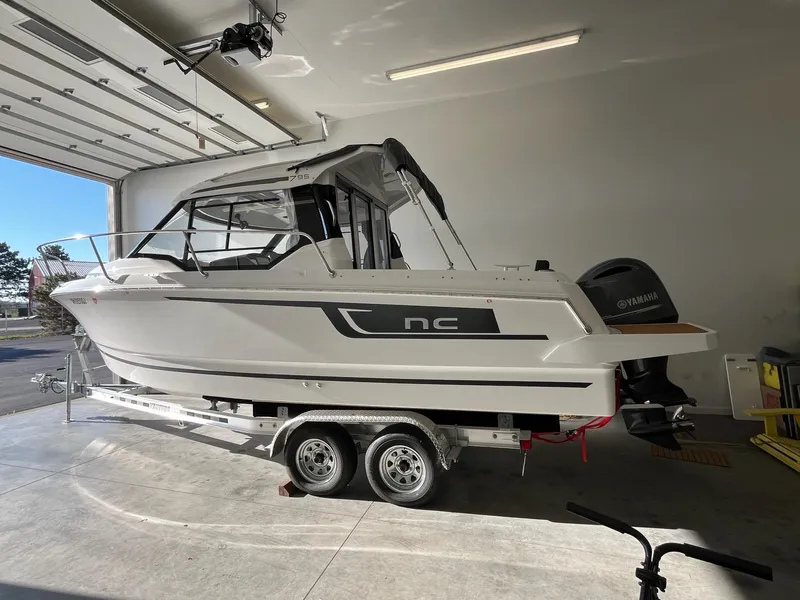 Slide: The Image of 2022 Jeanneau NC 795 boat on trailer in a garage setting. - 1