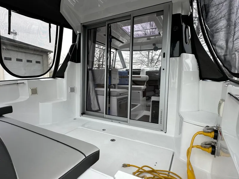 Slide: The Image of 2022 Jeanneau NC 795 boat interior with sliding glass doors and seating area. - 10