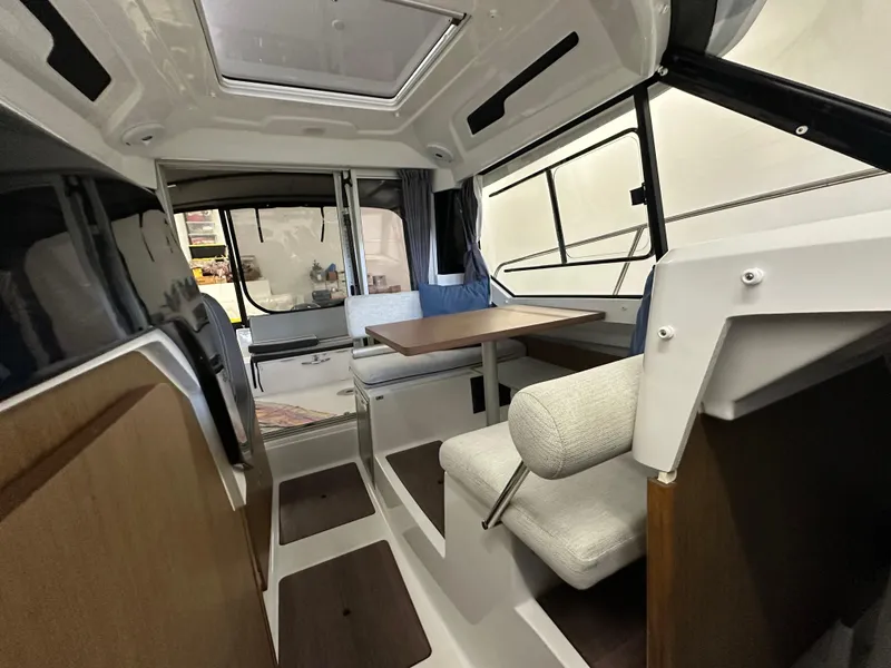 Slide: The Image of Interior of 2022 Jeanneau NC 795 boat, featuring seating and dining area with modern design. - 13
