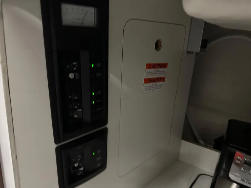 Slide: The Image of Control panel inside 2022 Jeanneau NC 795 boat, featuring switches and warning labels. - 17