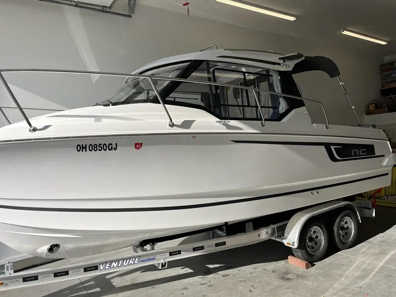 Slide: The Image of 2022 Jeanneau NC 795 boat on trailer in a garage setting. - 2