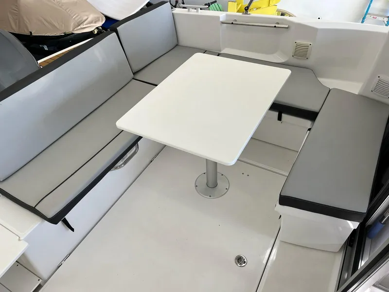 Slide: The Image of 2022 Jeanneau NC 795 boat interior with gray seating and white table. - 22