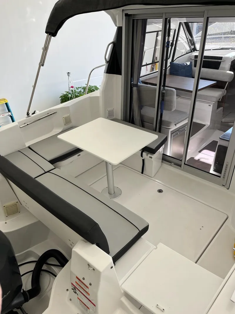Slide: The Image of 2022 Jeanneau NC 795 boat interior with seating and table, showcasing modern design. - 24