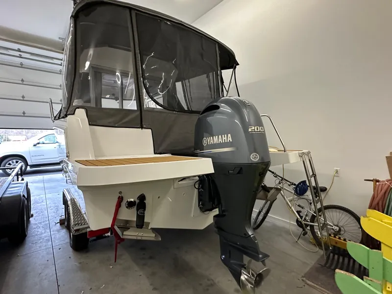 Slide: The Image of 2022 Jeanneau NC 795 boat with Yamaha 200 engine in a garage setting. - 28