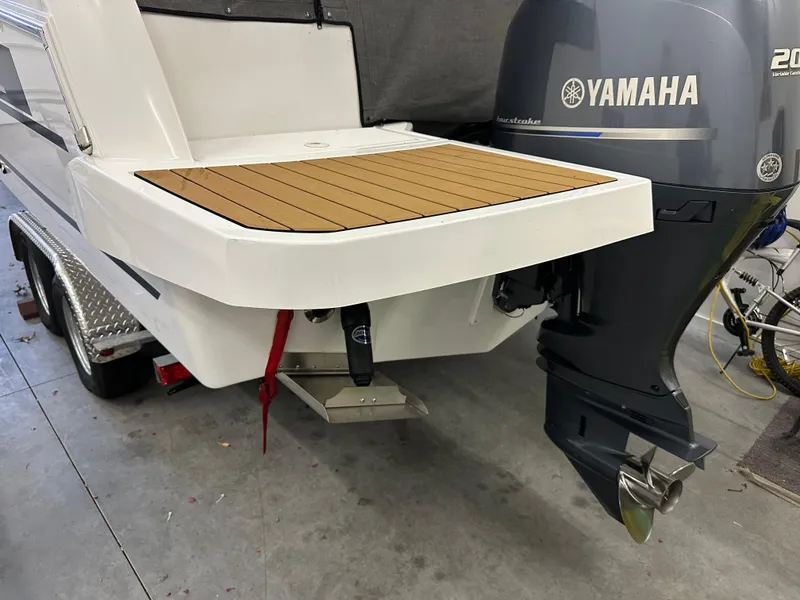 Slide: The Image of 2022 Jeanneau NC 795 boat with Yamaha outboard motor in a garage setting. - 29