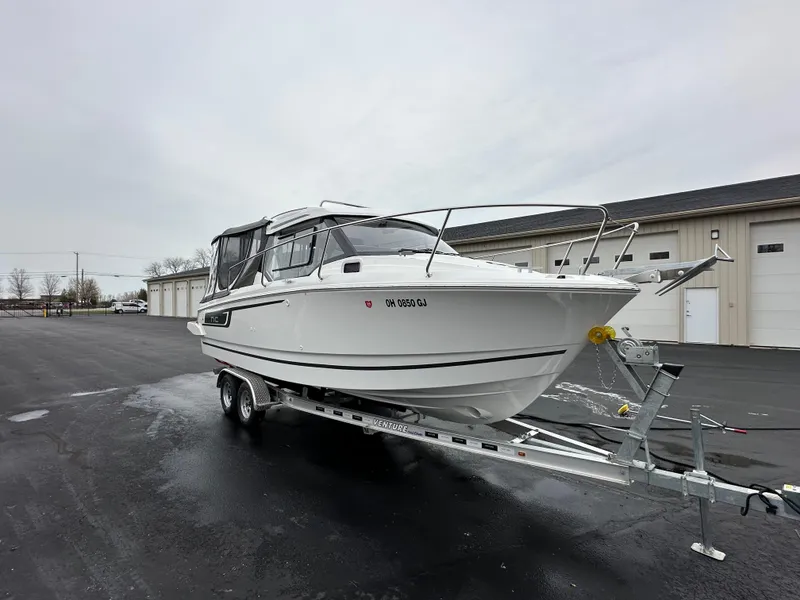 Slide: The Image of 2022 Jeanneau NC 795 boat on trailer, parked outdoors near storage facility. - 6