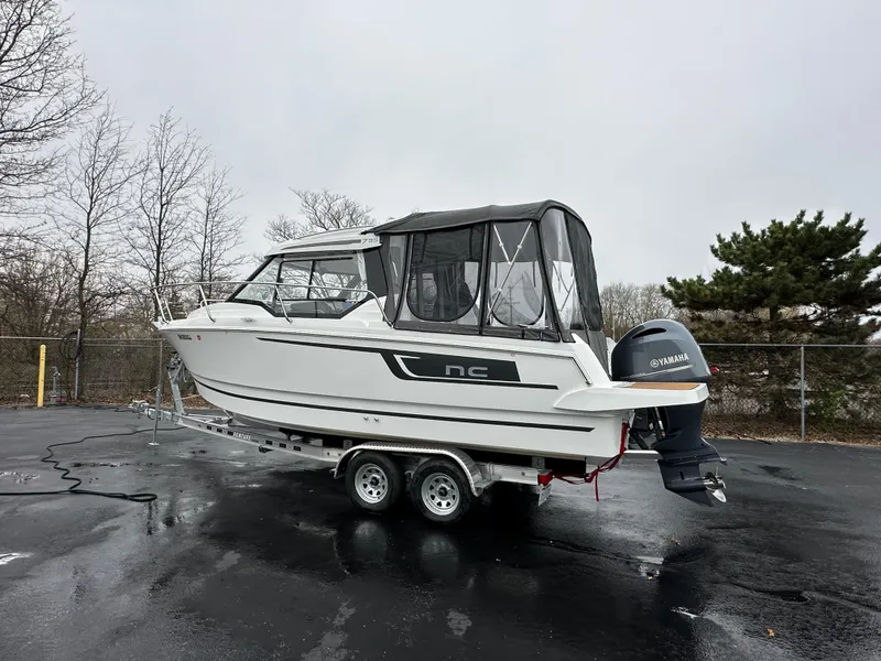 Slide: The Image of Jeanneau NC 795 boat, 2022 model, on trailer with Yamaha outboard motor, parked outdoors. - 8