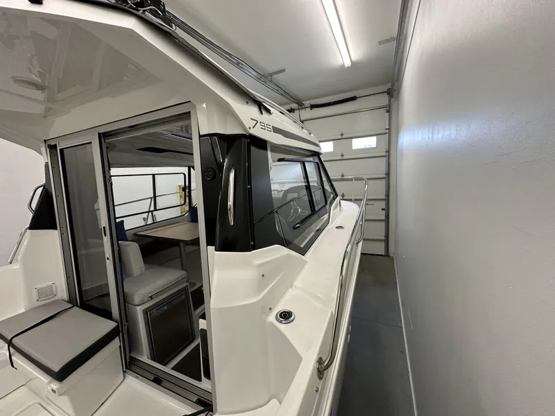 Slide: The Image of 2022 Jeanneau NC 795 boat in a garage, showcasing sleek design and modern interior. - 9