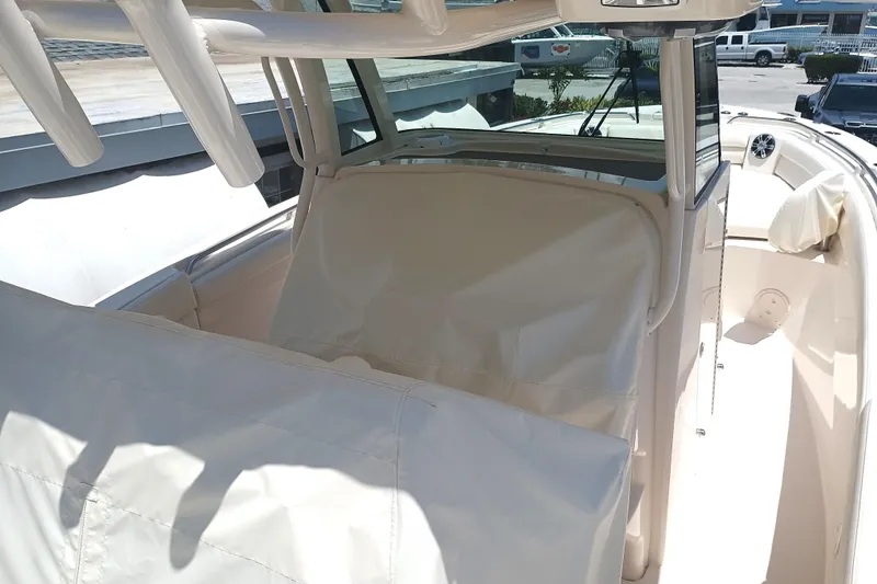 Slide: The Image of 2025 Grady-White Canyon 326 boat interior with protective covers, showcasing helm and seating area. - 11