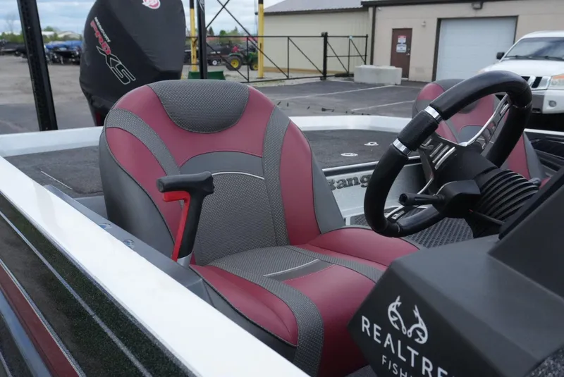 Slide: The Image of 2018 Ranger Z520L boat interior with red and gray seating, steering wheel, and Realtree branding. - 8