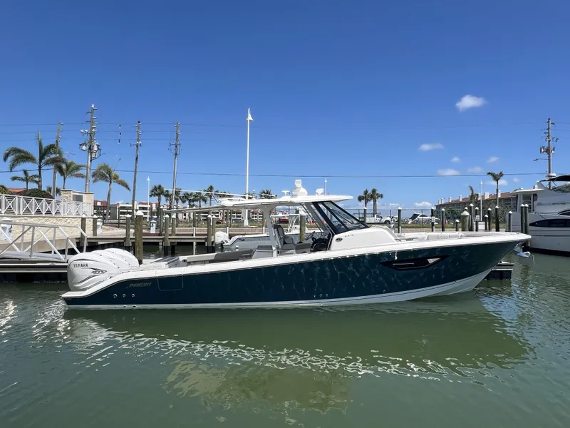 The Image of 2023 Pursuit S 378 Sport boat docked in a marina under clear blue skies. - 1