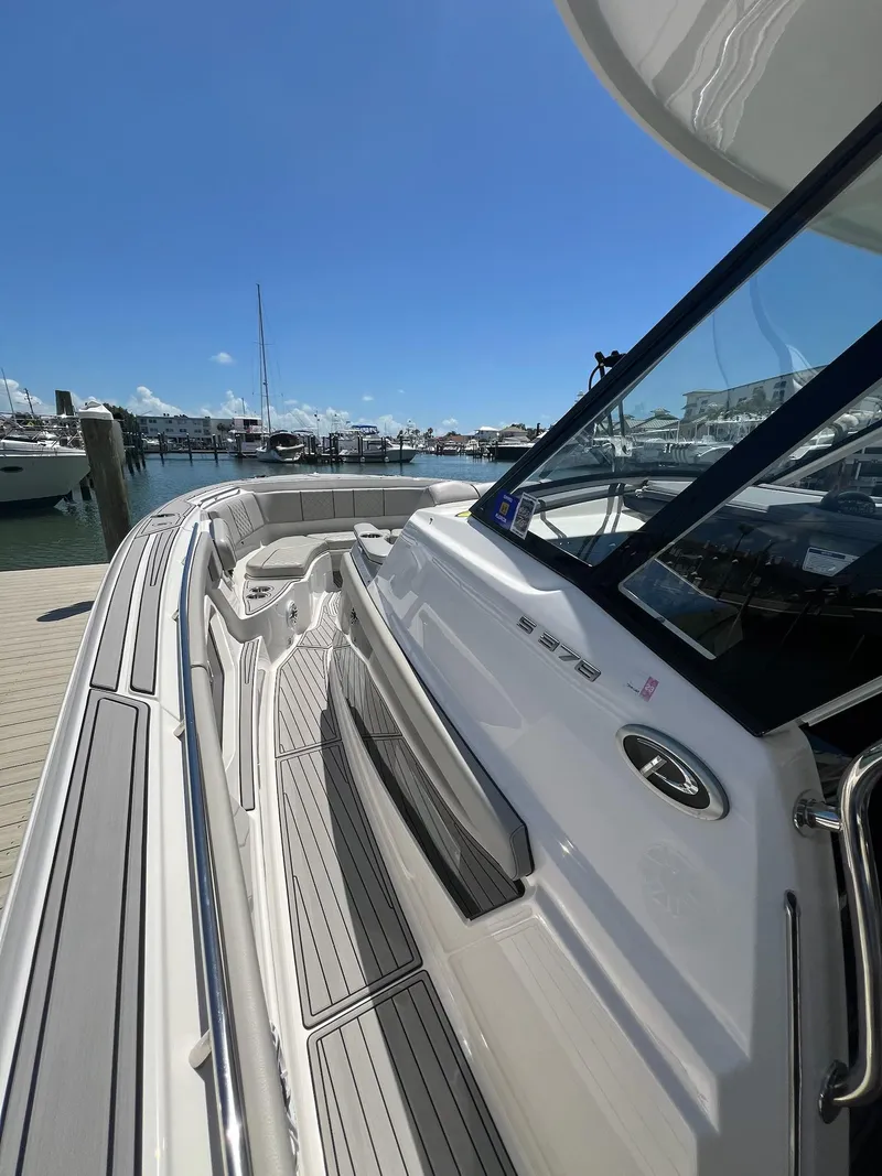 Slide: The Image of 2023 Pursuit S 378 Sport boat docked at marina under clear blue sky. - 17