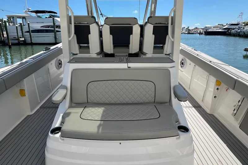Slide: The Image of 2023 Pursuit S 378 Sport boat interior with cushioned seating, docked at marina. - 4