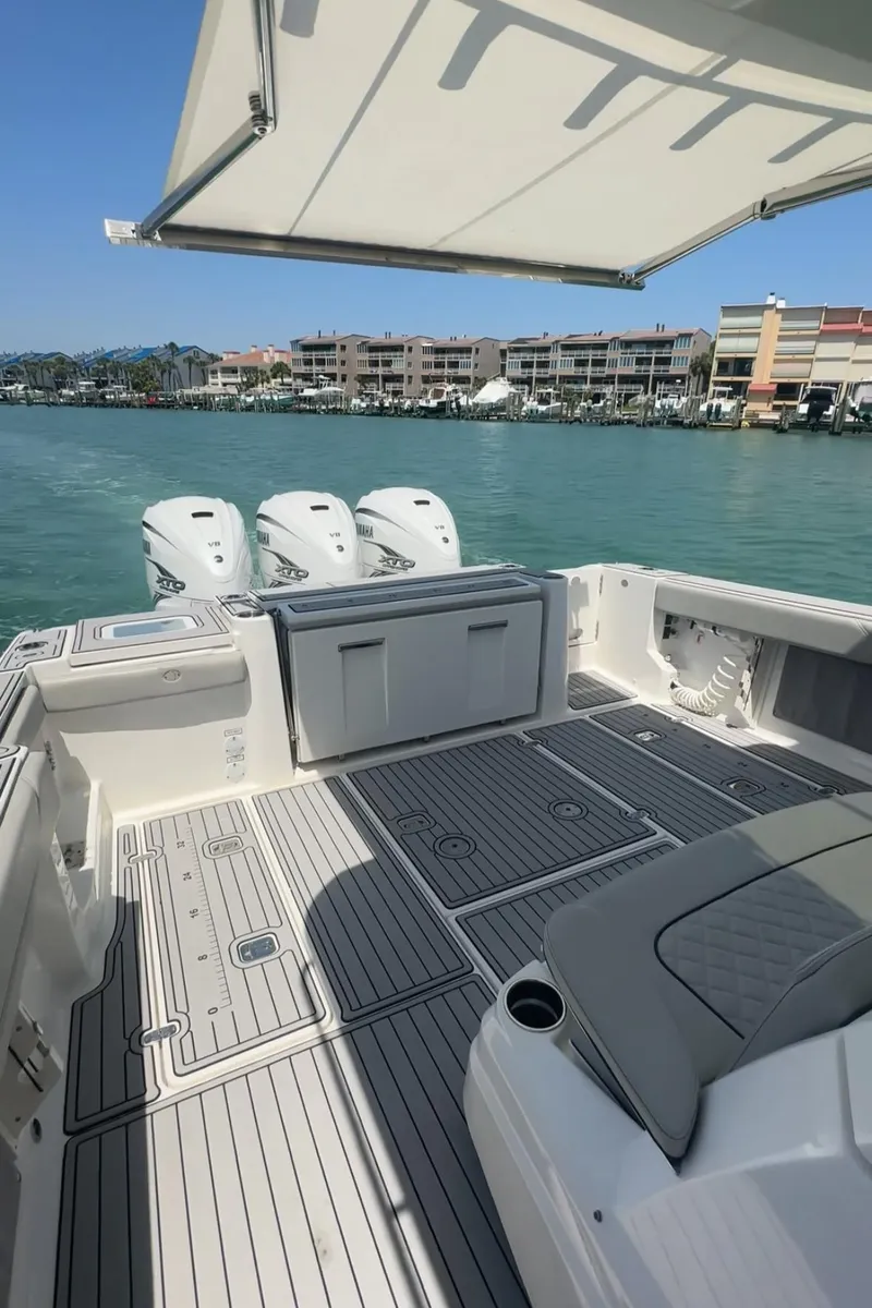 Slide: The Image of 2023 Pursuit S 378 Sport boat with triple engines, spacious deck, and waterfront view. - 6