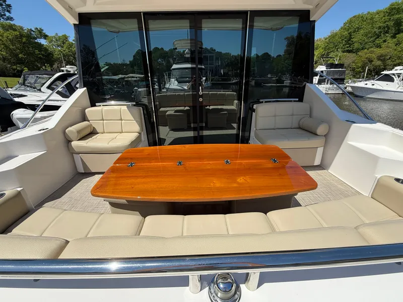 Slide: The Image of 2016 Tiara Yachts 50 Coupe with elegant outdoor seating and polished wooden table. - 11