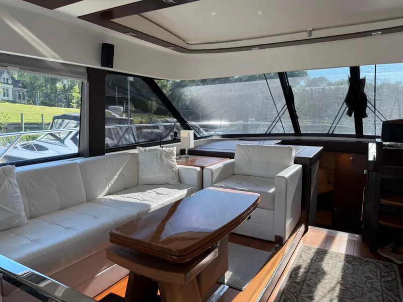 Slide: The Image of Luxurious interior of 2016 Tiara Yachts 50 Coupe with white seating and wooden table. - 12