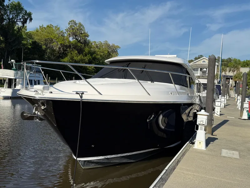 Slide: The Image of 2016 Tiara Yachts 50 Coupe docked, sleek design, black hull, sunny day. - 5