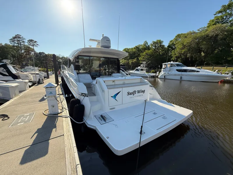 Slide: The Image of 2016 Tiara Yachts 50 Coupe docked at a marina under clear skies. - 6