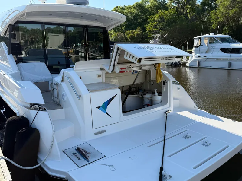 Slide: The Image of 2016 Tiara Yachts 50 Coupe docked, featuring open storage compartment and sleek design. - 7