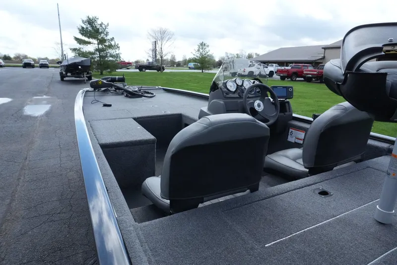 Slide: The Image of 2023 Tracker Pro 170 boat interior with steering console and seating on a paved road. - 13