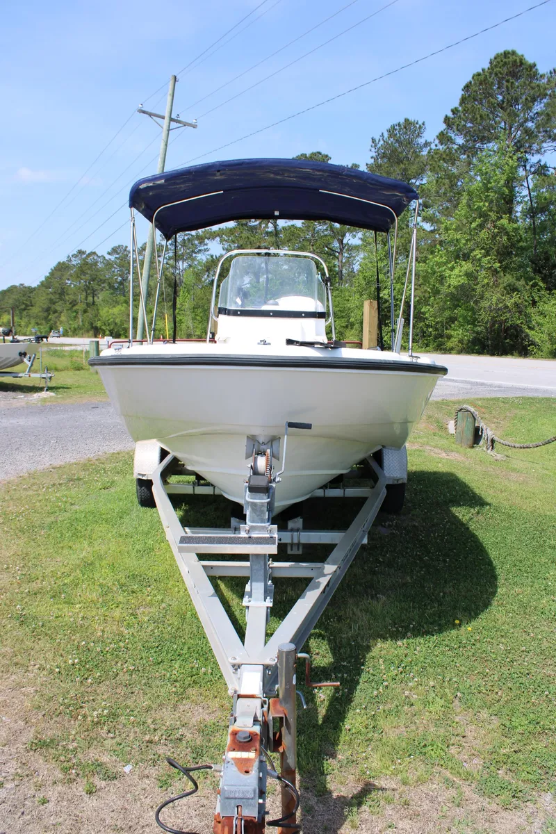 Slide: The Image of 2005 Boston Whaler 180 Dauntless boat on trailer with canopy, parked on grass. - 15
