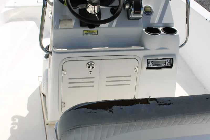 Slide: The Image of 2005 Boston Whaler 180 Dauntless boat console with steering wheel and storage compartment. - 17