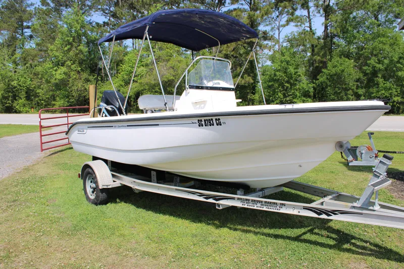 Slide: The Image of 2005 Boston Whaler 180 Dauntless boat on trailer with canopy, parked on grass. - 5
