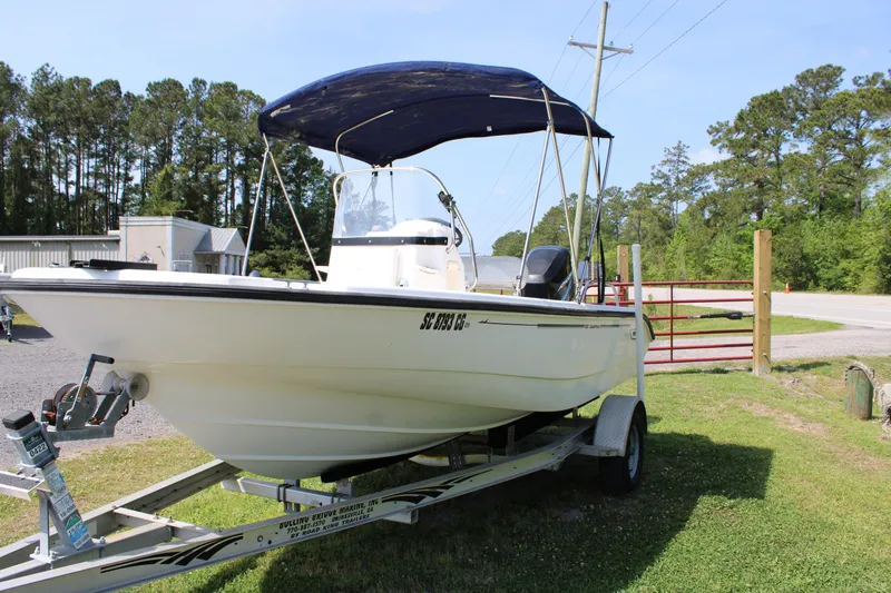 Slide: The Image of 2005 Boston Whaler 180 Dauntless boat on trailer with canopy, parked outdoors. - 6