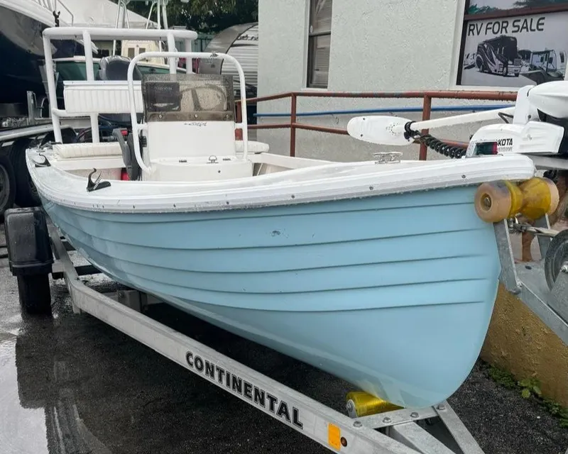 Slide: The Image of 2022 Salt Creek 1500 boat on trailer, light blue hull, parked outdoors. - 2