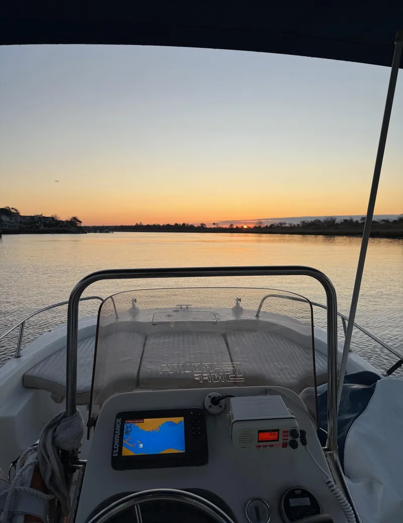 Slide: The Image of 2018 Carolina Skiff 198 DLV boat at sunset on calm water. - 13