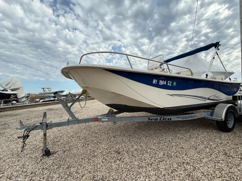 Slide: The Image of 2018 Carolina Skiff 198 DLV boat on trailer under cloudy sky. - 16