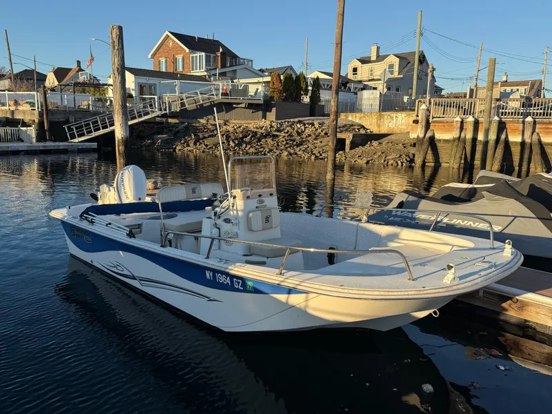 Slide: The Image of 2018 Carolina Skiff 198 DLV boat docked in a marina with waterfront homes. - 11