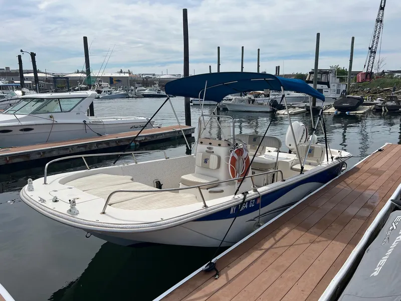 Slide: The Image of 2018 Carolina Skiff 198 DLV boat docked at marina with blue canopy. - 7