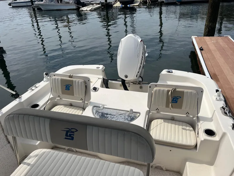 Slide: The Image of 2018 Carolina Skiff 198 DLV boat interior with seating and motor at dock. - 9