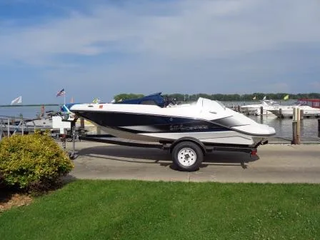 Slide: The Image of 2016 Scarab 165G boat on trailer by lakeside dock, clear sky background. - 3