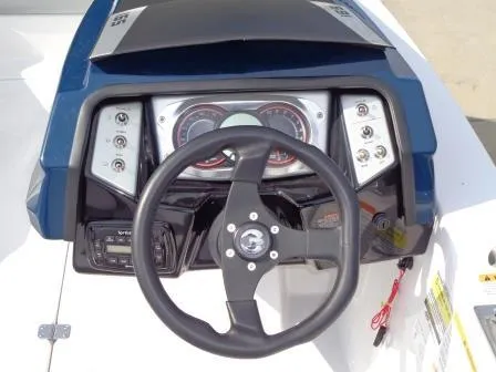Slide: The Image of Steering wheel and dashboard of 2016 Scarab 165G boat, featuring modern controls and gauges. - 6