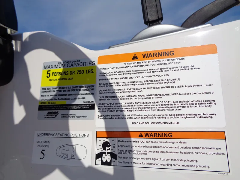 Slide: The Image of Warning labels on a 2016 Scarab 165G boat, detailing safety and capacity information. - 8